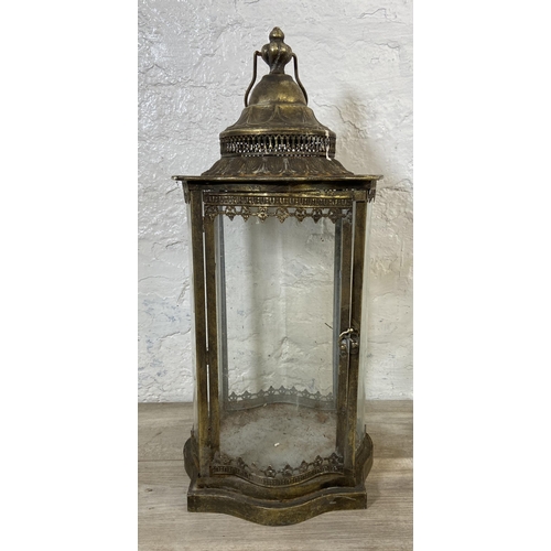 48 - Two items, one wrought metal four branch candelabra and one gilt metal garden lantern - approx. 63cm... 