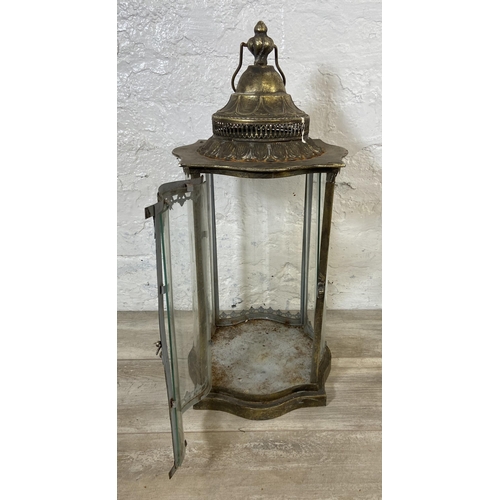 48 - Two items, one wrought metal four branch candelabra and one gilt metal garden lantern - approx. 63cm... 