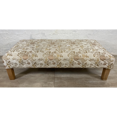 62 - A modern floral fabric upholstered footstool on beech supports - approx. 35cm high x 62cm wide x 124... 