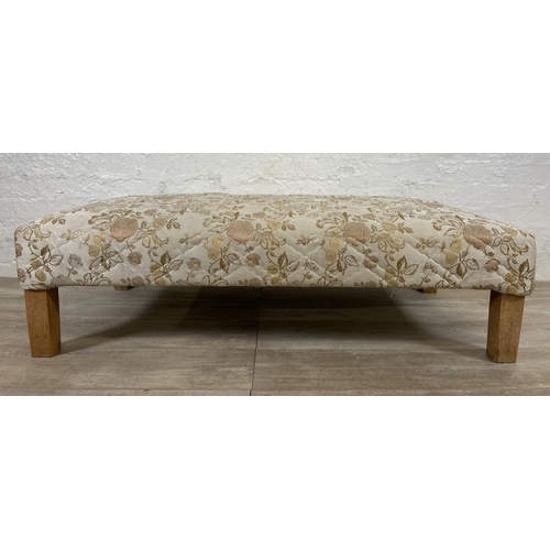 62 - A modern floral fabric upholstered footstool on beech supports - approx. 35cm high x 62cm wide x 124... 