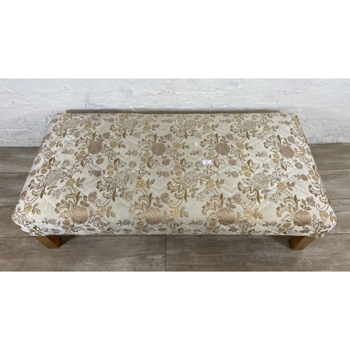 62 - A modern floral fabric upholstered footstool on beech supports - approx. 35cm high x 62cm wide x 124... 