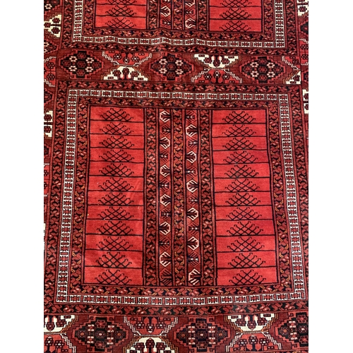 8 - A Persian red ground machine woven rug - approx. 240cm x 156cm