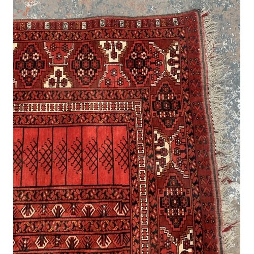 8 - A Persian red ground machine woven rug - approx. 240cm x 156cm