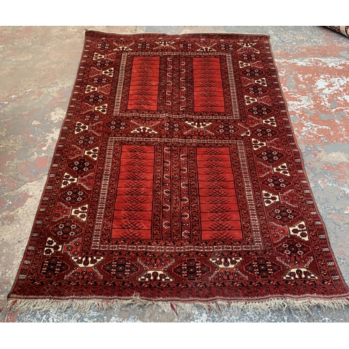 8 - A Persian red ground machine woven rug - approx. 240cm x 156cm