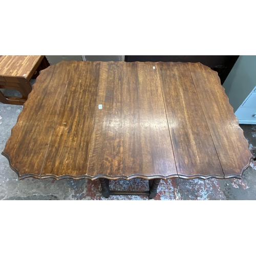 80 - An early 20th century oak pie crust edge drop leaf gate leg dining table on barley twist supports