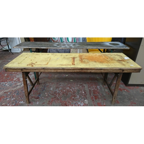 83 - Two vintage wooden folding trestle tables, one beech with yellow painted top and one pine on green m... 