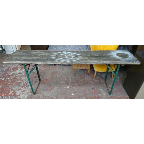 83 - Two vintage wooden folding trestle tables, one beech with yellow painted top and one pine on green m... 