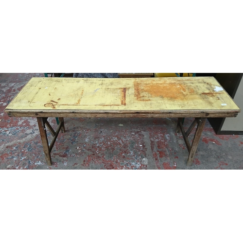 83 - Two vintage wooden folding trestle tables, one beech with yellow painted top and one pine on green m... 