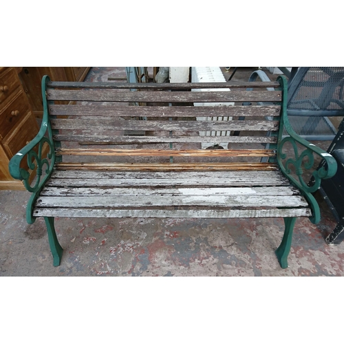 86 - A cast iron and wooden slatted garden bench