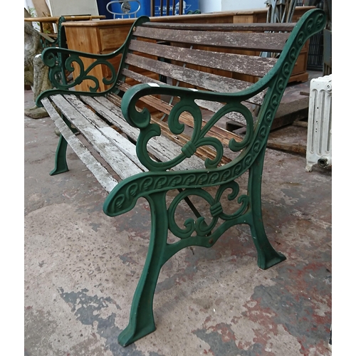 86 - A cast iron and wooden slatted garden bench