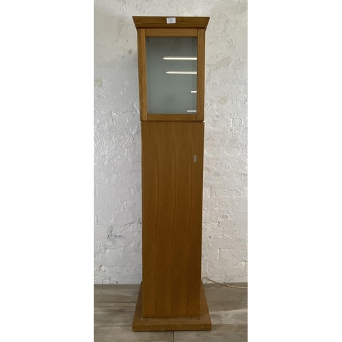 151 - A modern oak illuminating cabinet - approx. 149cm high x 40cm wide x 40cm deep