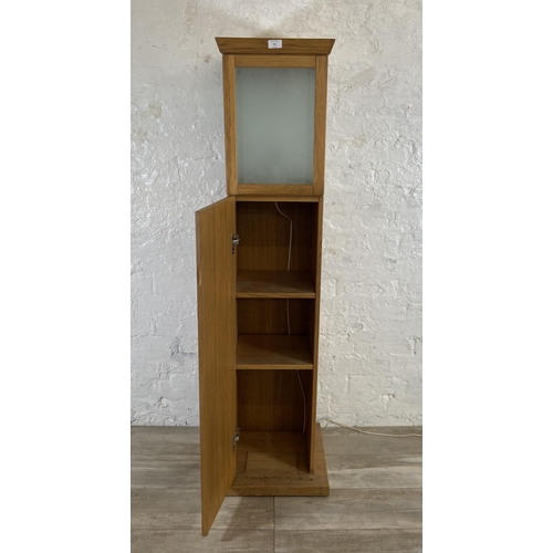 151 - A modern oak illuminating cabinet - approx. 149cm high x 40cm wide x 40cm deep