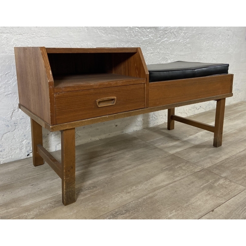 154 - A mid 20th century teak telephone table with black vinyl cushion - approx. 54cm high x 100cm wide x ... 