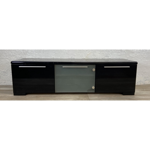 155 - A modern black laminate TV stand - approx. 43cm high x 148cm wide x 40cm deep