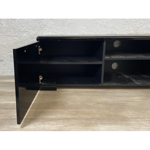 155 - A modern black laminate TV stand - approx. 43cm high x 148cm wide x 40cm deep