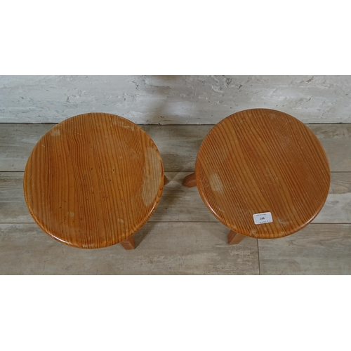 166 - A pair of pine circular top height adjustable stools