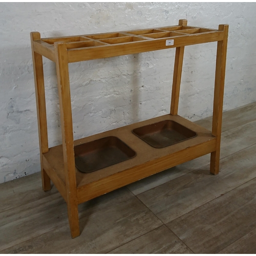 168 - A mid 20th century beech eight section stick stand with two metal drip trays - approx. 71cm high x 7... 