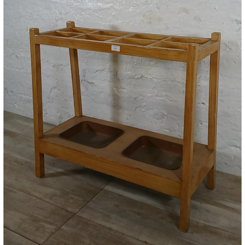 168 - A mid 20th century beech eight section stick stand with two metal drip trays - approx. 71cm high x 7... 