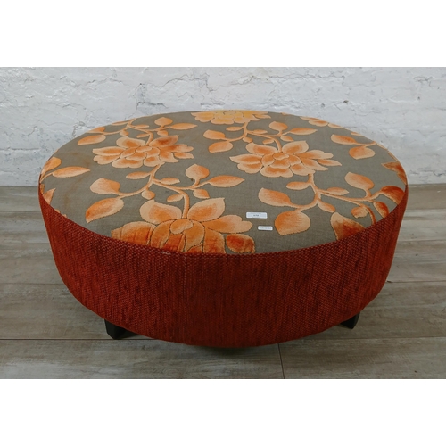 172 - A modern orange and grey floral fabric upholstered circular footstool - approx. 34cm high x 89cm dia... 