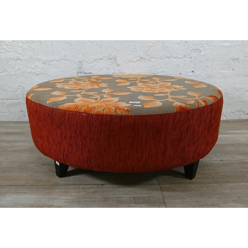 172 - A modern orange and grey floral fabric upholstered circular footstool - approx. 34cm high x 89cm dia... 