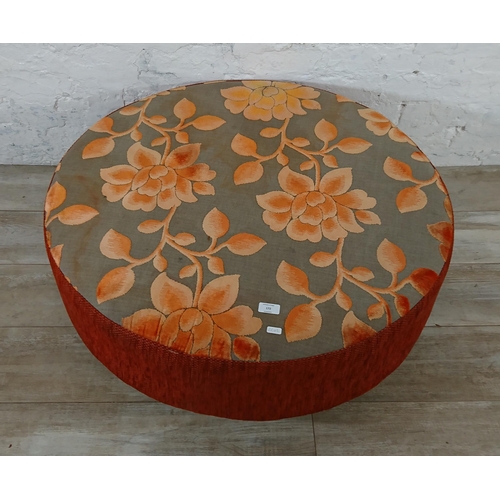 172 - A modern orange and grey floral fabric upholstered circular footstool - approx. 34cm high x 89cm dia... 