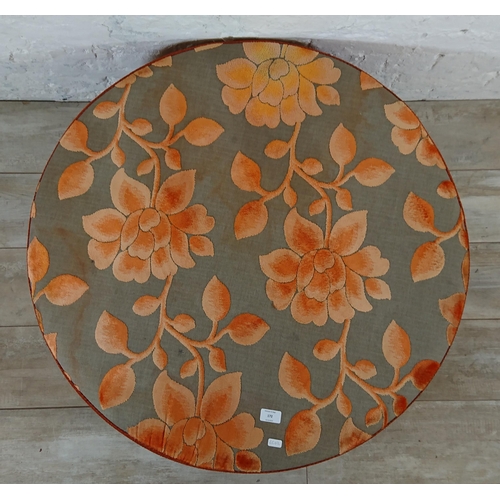 172 - A modern orange and grey floral fabric upholstered circular footstool - approx. 34cm high x 89cm dia... 