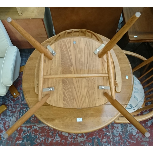 182 - Four pieces of furniture, three Ercol Windsor blonde elm dining chairs and one beech circular pedest... 