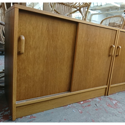 187 - Two mid/late 20th century oak two door office cabinets - approx. 72cm high x 91cm wide x 46cm deep