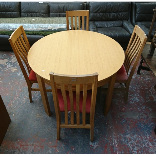 199 - A modern oak circular extending dining table and four chairs - approx. 75cm high x 120cm diameter