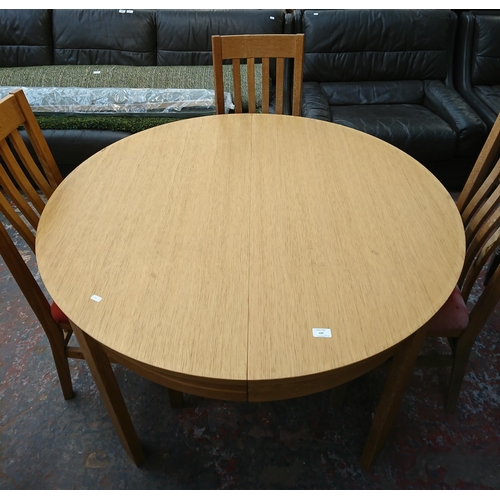 199 - A modern oak circular extending dining table and four chairs - approx. 75cm high x 120cm diameter