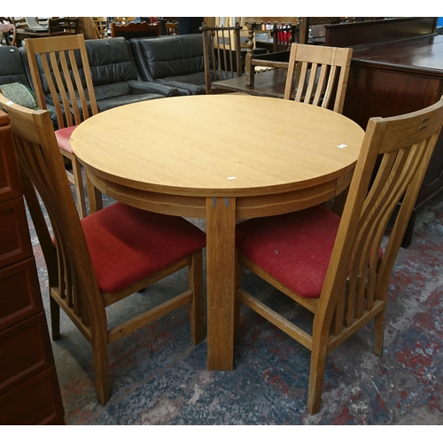 199 - A modern oak circular extending dining table and four chairs - approx. 75cm high x 120cm diameter