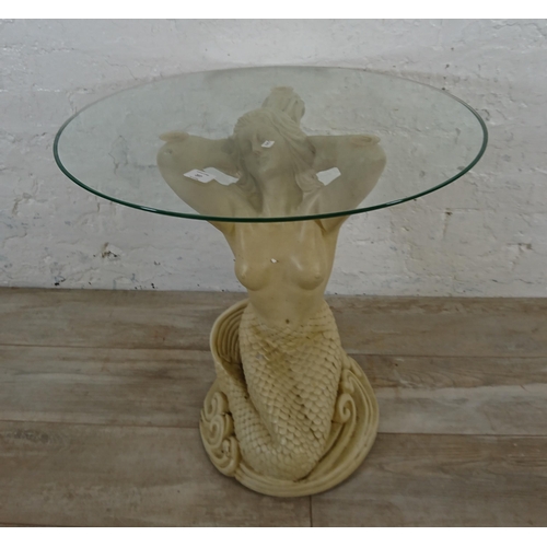 207 - A resin mermaid side table with glass top - approx. 57cm high x 61cm diameter