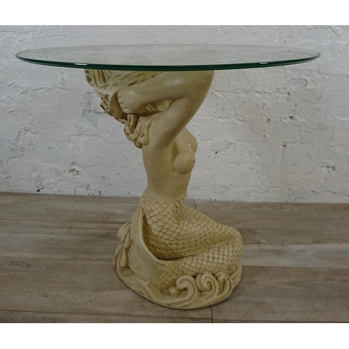 207 - A resin mermaid side table with glass top - approx. 57cm high x 61cm diameter