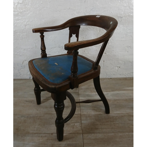 220B - An early 20th century elm and beech captains desk chair with later added blue vinyl upholstery