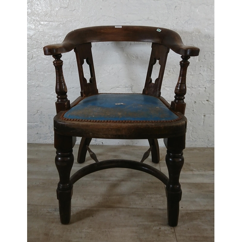 220B - An early 20th century elm and beech captains desk chair with later added blue vinyl upholstery