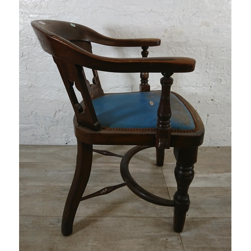 220B - An early 20th century elm and beech captains desk chair with later added blue vinyl upholstery