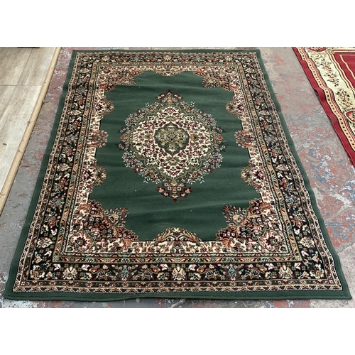 226 - A modern green ground machine woven rug - approx. 218cm x 161cm