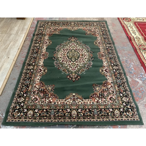 226 - A modern green ground machine woven rug - approx. 218cm x 161cm