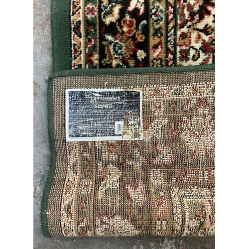 226 - A modern green ground machine woven rug - approx. 218cm x 161cm