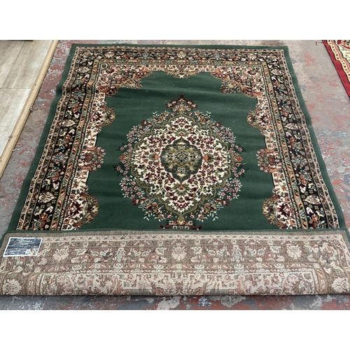 226 - A modern green ground machine woven rug - approx. 218cm x 161cm