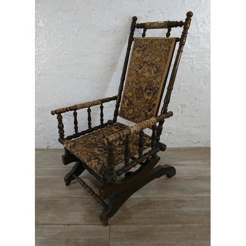 227 - An early 20th century American beech and tapestry upholstered rocking chair