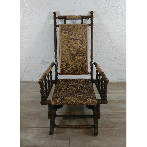 227 - An early 20th century American beech and tapestry upholstered rocking chair