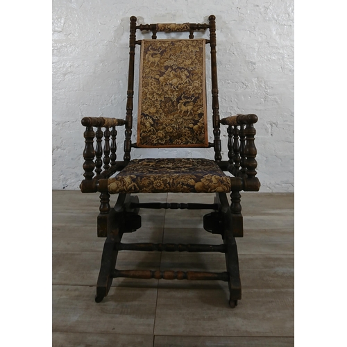 227 - An early 20th century American beech and tapestry upholstered rocking chair