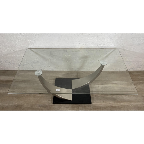 235 - A modern glass top coffee table on metal pedestal base - approx. 47cm high x 71cm wide x 126cm long