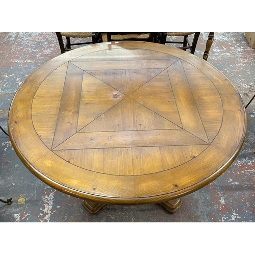 235A - A pine and wrought metal circular dining table and four rattan seated chairs - approx. 75cm high x 1... 