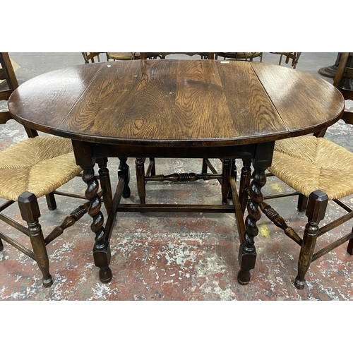 236 - An early 20th century oak drop leaf barley twist dining table and four 19th century style beech and ... 