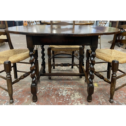 236 - An early 20th century oak drop leaf barley twist dining table and four 19th century style beech and ... 