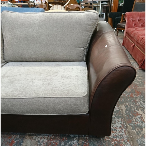 241 - A Marks & Spencer brown leather three seater sofa with later added grey fabric cushions