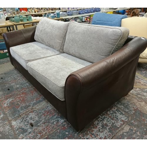 241 - A Marks & Spencer brown leather three seater sofa with later added grey fabric cushions