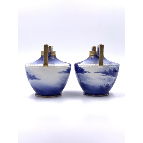 334 - A pair of Royal Doulton Children's Series blue transfer printed and gilded twin handled vases - appr... 